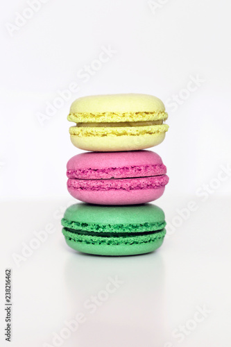 Fototapeta Naklejka Na Ścianę i Meble -  Yellow, pink and green french macarons on the white table. Close-up, front view, copy space