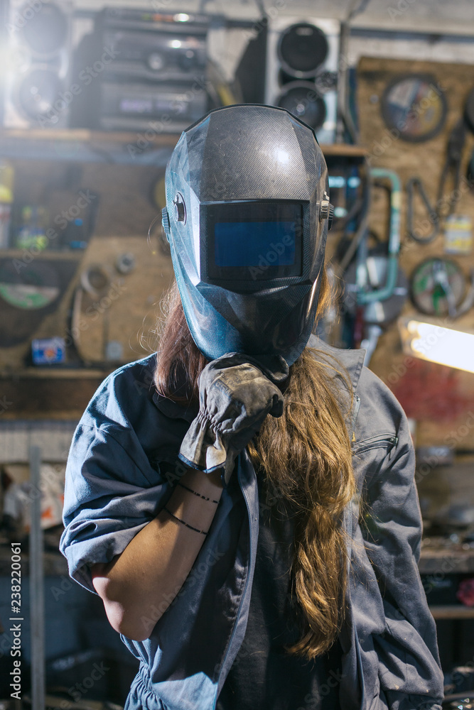 woman with welding mask in workshop - obrazy, fototapety, plakaty 