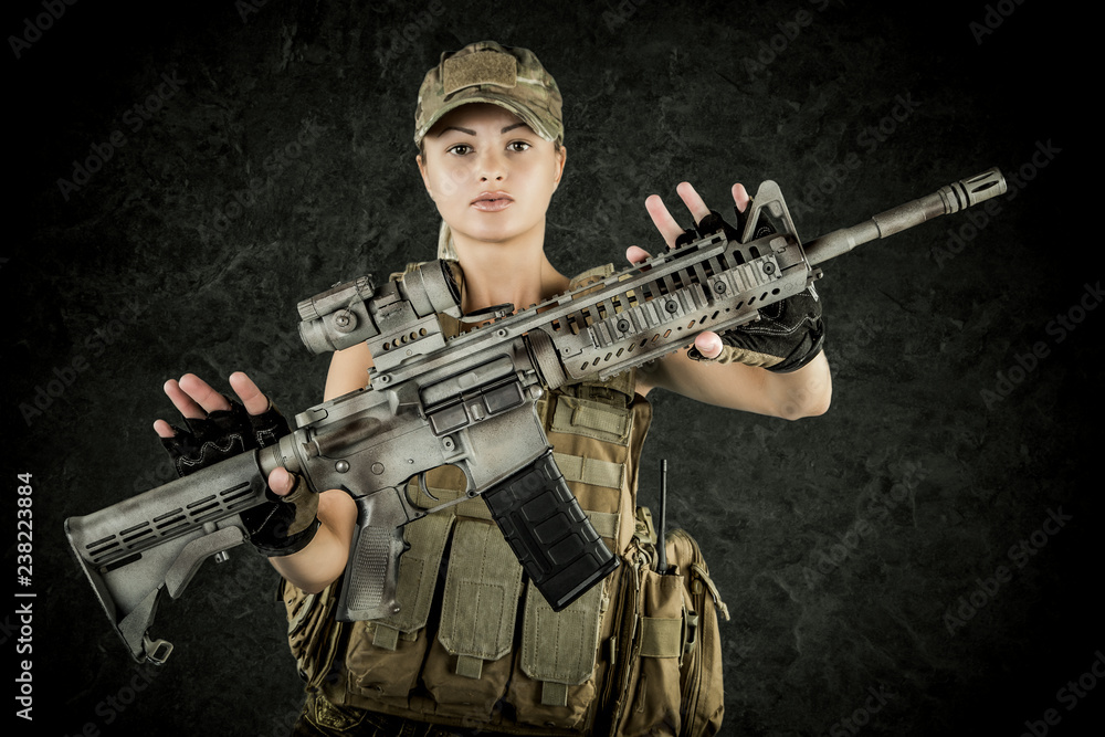 Sexy girl wearing military style posing with guns and sunglases isolated in studio Sexy girl wearing military style posing with guns and sunglases isolated in studio