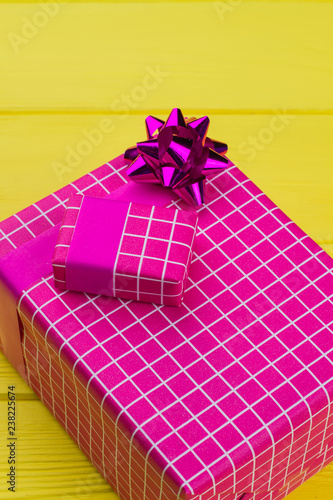 Stylish gift boxes on color background. Present boxes packed in modern pink paper. Christmas holiday background.