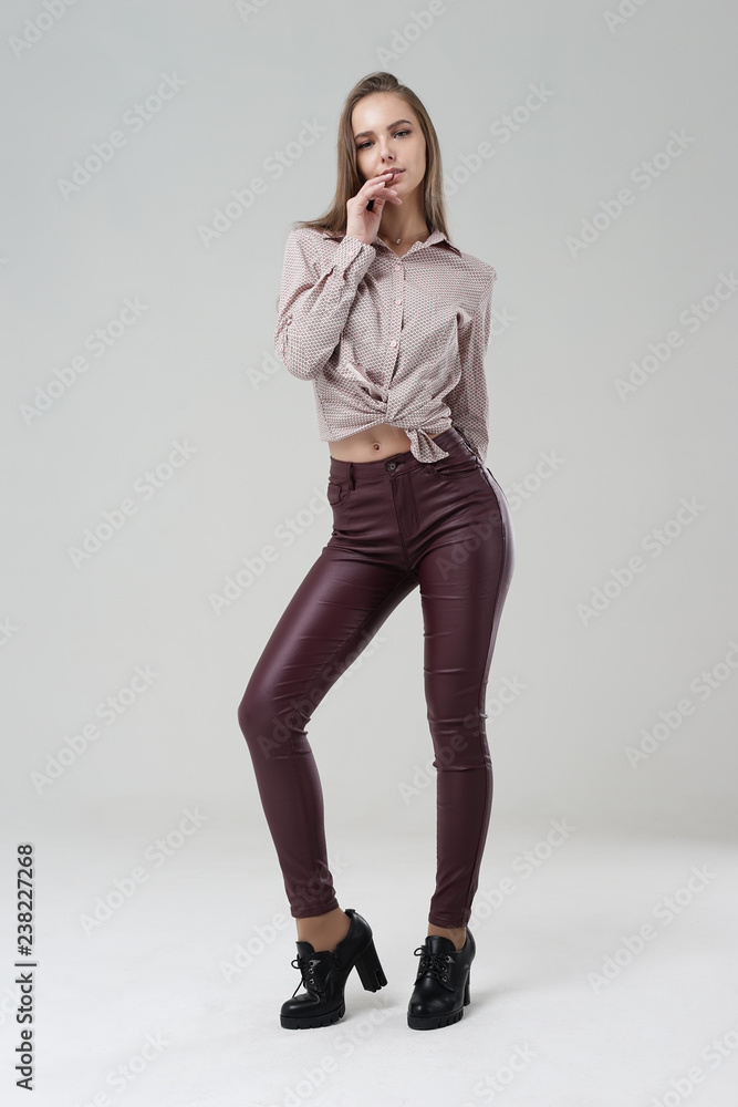 Young girl in tight red leather pants posing in Studio Stock Photo | Adobe  Stock