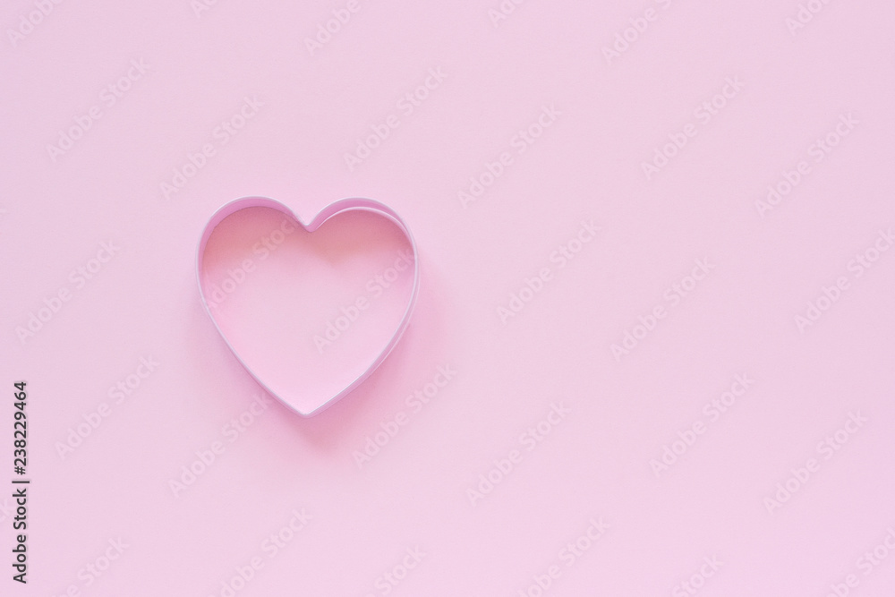 One cutter cookies in heart shape on pastel pink background. Concept Valentine's card. Top view Copy space for text.