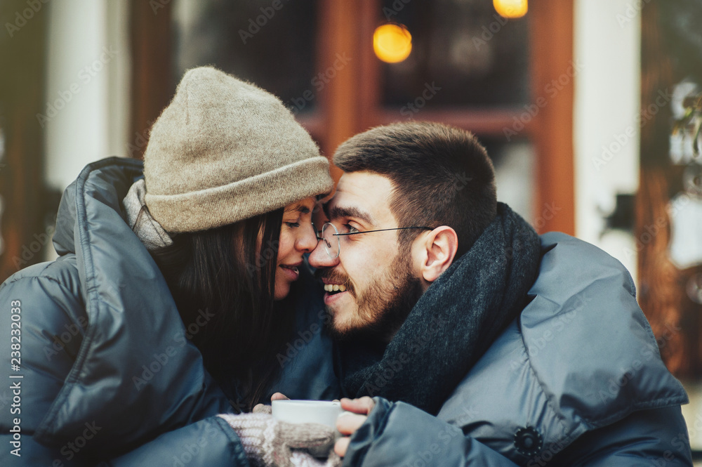 Young romantic couple is having fun outdoors in winter before Ch Young romantic couple is having fun outdoors in winter before Ch