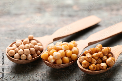 Roasted and dry chickpeas in spoons on grey wooden table