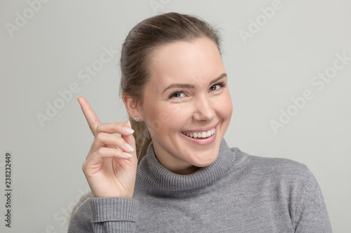 Принти на полотні Hübsche Frau im grauen Rollkragenpulli freut sich über eine Idee