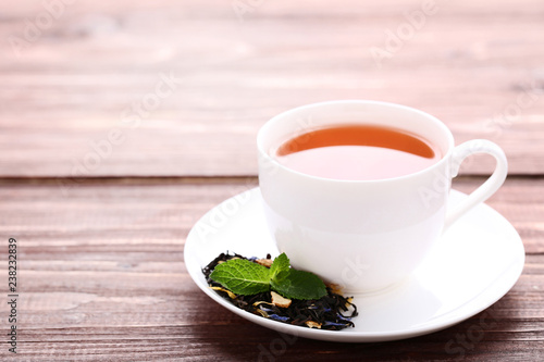 Cup of tea with mint leafs on brown wooden table