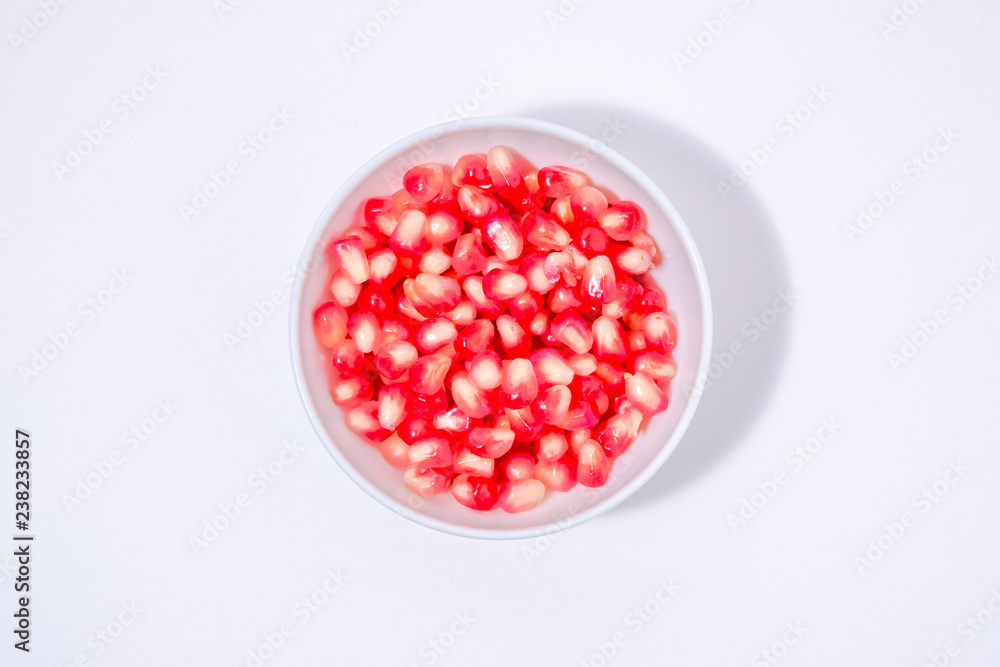 pomegranate seeds in a white bowl pomegranate seeds in a white bowl