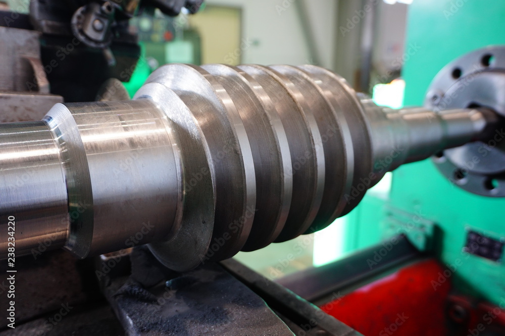 Grinding of the worm shaft on the backing machine. Industrial industry manufacturing gear shafts. Grinding of the worm shaft on the backing machine. Industrial industry manufacturing gear shafts.