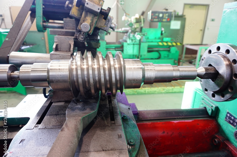 Grinding of the worm shaft on the backing machine. Industrial industry manufacturing gear shafts. Grinding of the worm shaft on the backing machine. Industrial industry manufacturing gear shafts.