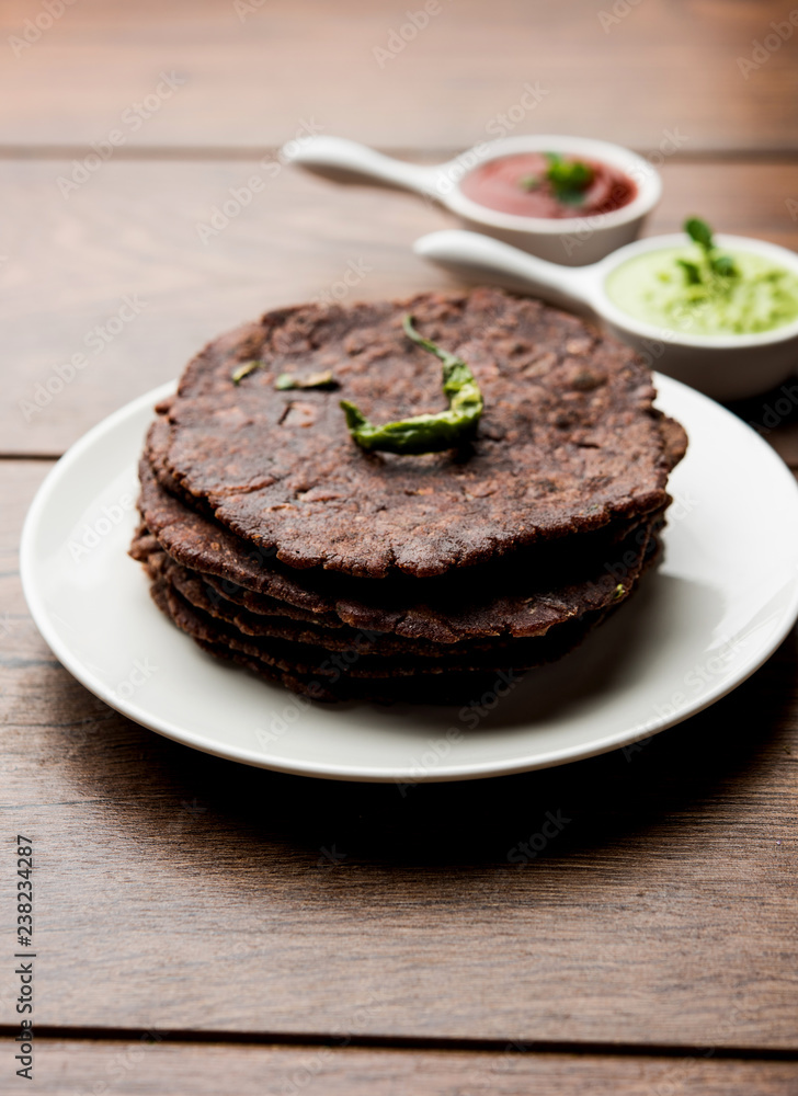 Ragi roti or flat Bread made using finger millet is a healthy and tasty breakfast dish of Karnataka, India. served with green chilli and chutney. selective focus Ragi roti or flat Bread made using finger millet is a healthy and tasty breakfast dish of Karnataka, India. served with green chilli and chutney. selective focus