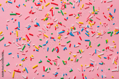trendy pattern of colorful sprinkles over pink background, decoration for cak...