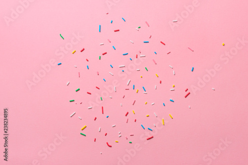 beautiful sugar colorful sprinkles over pink background