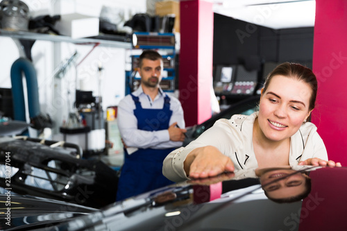 Woman admiring car after repainting