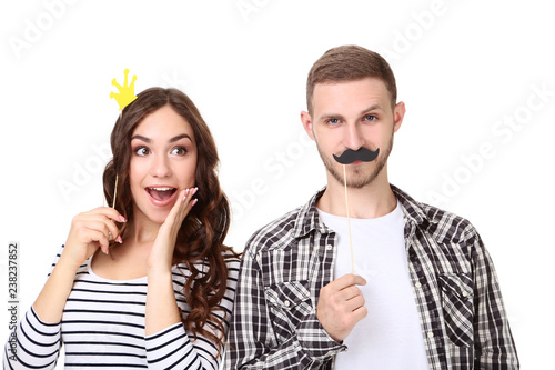 Beautiful young couple with paper booth props isolated on white background