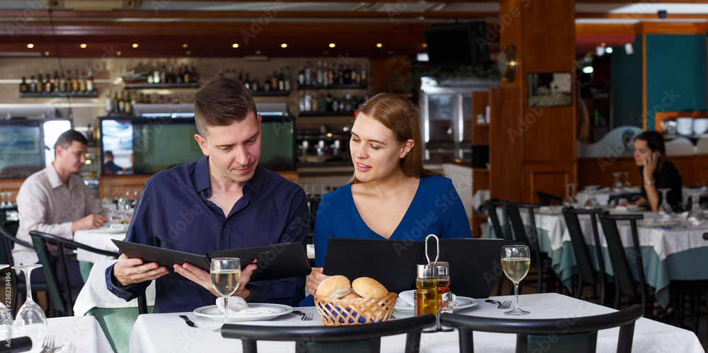Couple and reading menu in restaurant