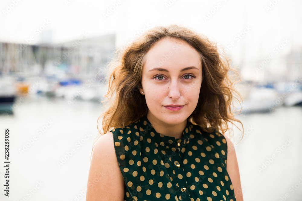 Close up of young attractive woman tourist  at quay  with sailboats