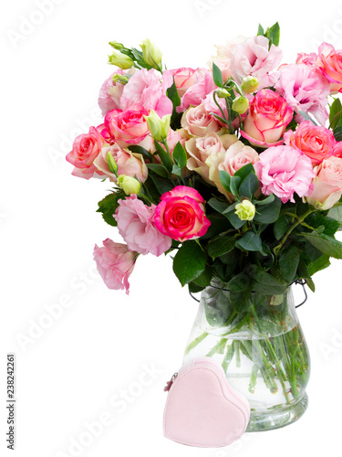 Rose and eustoma fresh flowers bouquet in two shades of pink in glass vase close up isolated on white background
