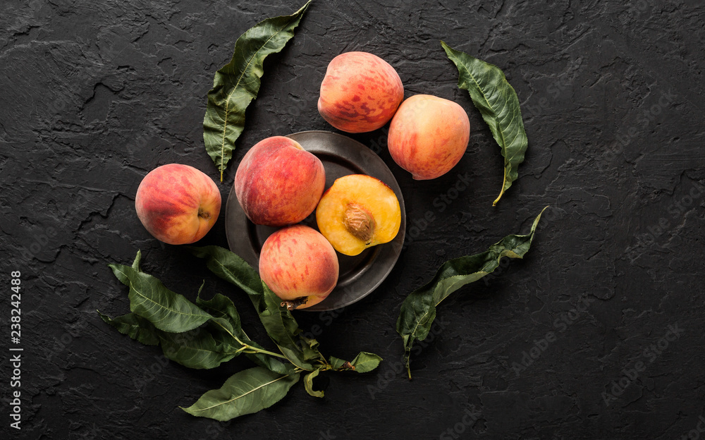 Ripe peaches on black stone background. Healthy food concept, top view, copy space - obrazy, fototapety, plakaty 