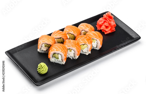 Sushi Roll - Maki Sushi made of salmon, avocado and cream cheese on black plate isolated over white background. Japanese cuisine