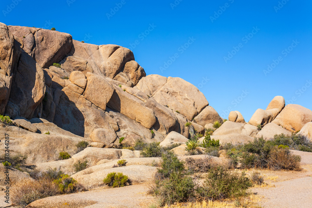 Boulder rosks at Joshua Tree National Park in California with clear blue sky