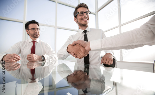 handshake of young business partners at the office table