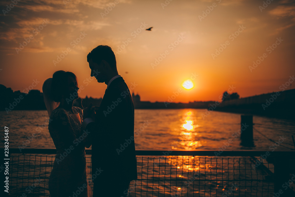 Two silhouettes of a man and a woman at sunset