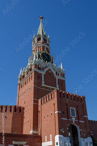 Spasskaya tower of the Moscow Kremlin with clock chimes against the blue sky