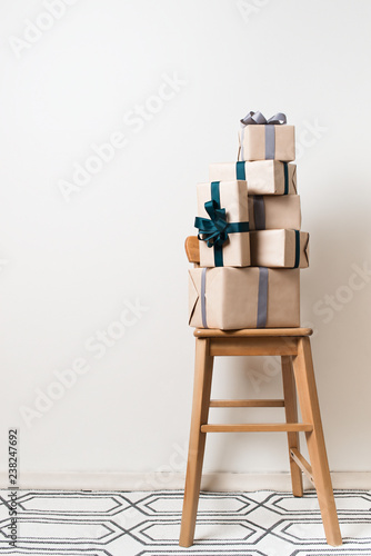 Scandinavian minimalism christmas and new year concept - gift box on a chair in room