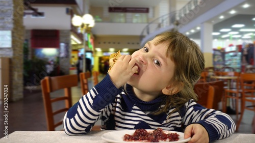 A funny child of European appearance on a food court.