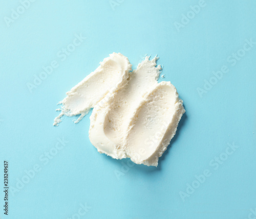 Smear of tasty cream cheese on color background, top view