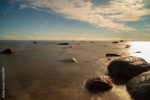 rock covered beach in countryside in Latvia  large rocks in water