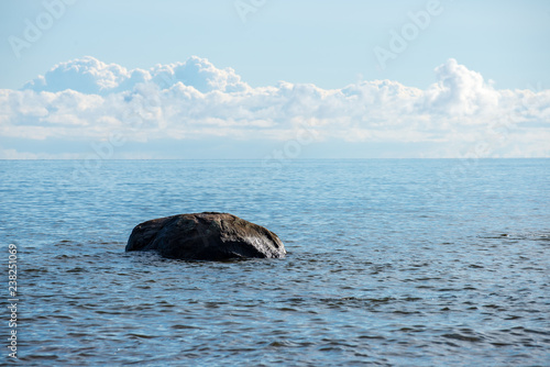 rock covered beach in countryside in Latvia, large rocks in water © Martins Vanags
