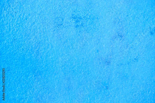 The texture of thin layer of ice or snow colored in blue, background