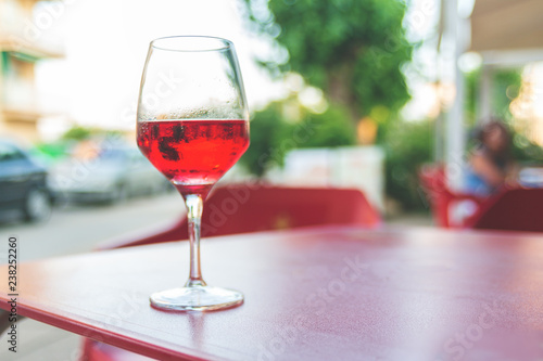 Glass of rose wine on the table in street cafe Vintage toning Selective focus Copy space