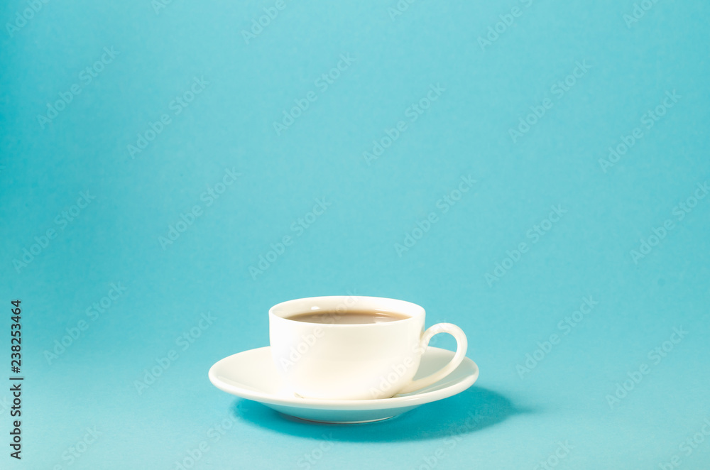 Fototapeta premium white cup with black coffee on a blue background/white cup with a saucer full of black coffee on a blue background