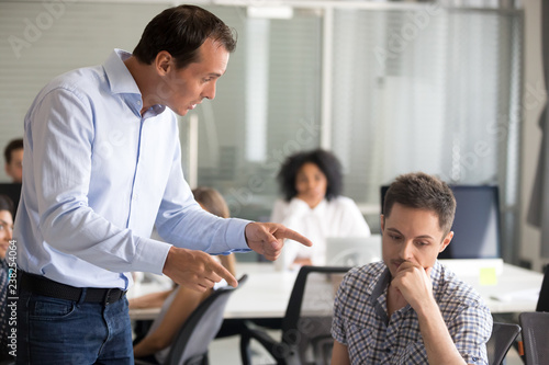 Slika na platnu Angry boss scolding frustrated incompetent employee at workplace, dissatisfied l