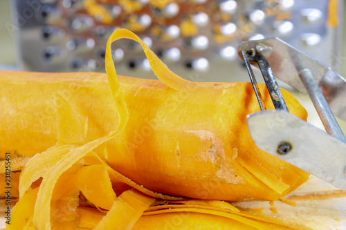 Fresh carrot grated on a metal kitchen grate. Vegetables prepared for salad with a meal on the kitchen table. photo