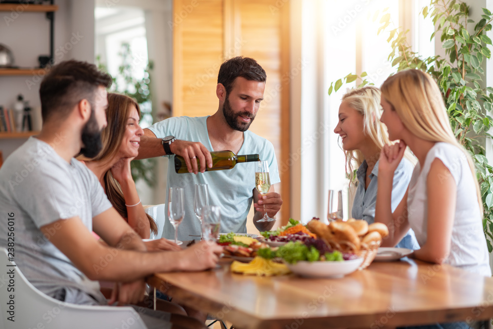 Smiling friends having lunch together at home Smiling friends having lunch together at home