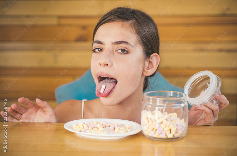 Marshmallow paradise. Funny woman enjoy eating marshmallows. Pretty woman hold marshmallows on her tongue. Candy girl with sweet confectionery. Junk food. Unhealthy and harmful food. Sweet snack Marshmallow paradise. Funny woman enjoy eating marshmallows. Pretty woman hold marshmallows on her tongue. Candy girl with sweet confectionery. Junk food. Unhealthy and harmful food. Sweet snack