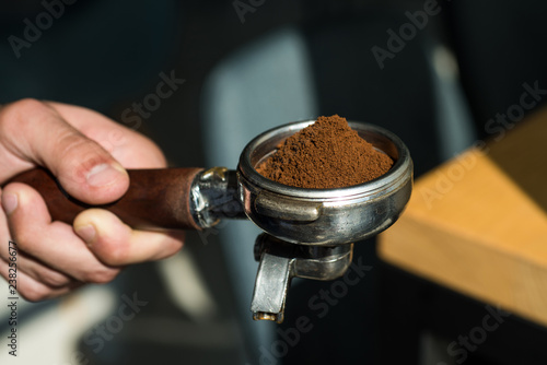 Let our passion be your pleasure. Brewing coffee equipment. Barista hold portafilter in hand. Barista brews espresso coffee in cafe. Coffee making in coffeehouse. Fresh ground coffee