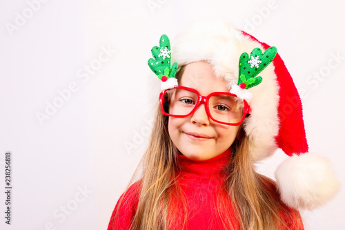 Close up portrait cute and funny blond little girl wearing red christmas sweater with turtleneck  making funny faces and being silly on isolated background with copy space. Christmas mood concept.