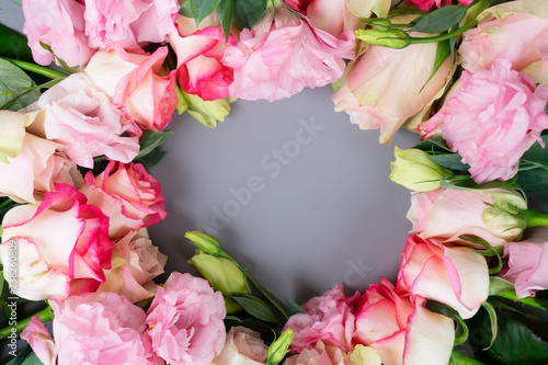 Rose fresh flowers bouquet frame on gray table from above, flat lay scene