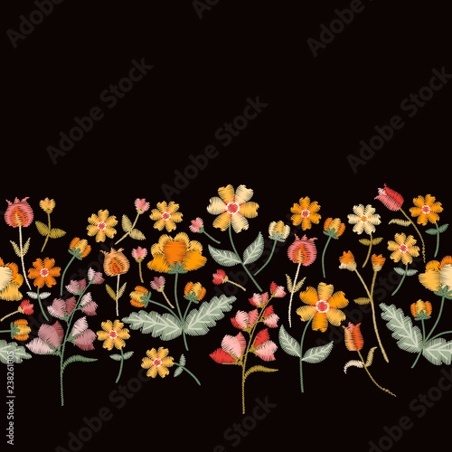 Vector embroidery border with cute wild flowers. Seamless floral embroidered pattern on black background. Fahion design for clothing.