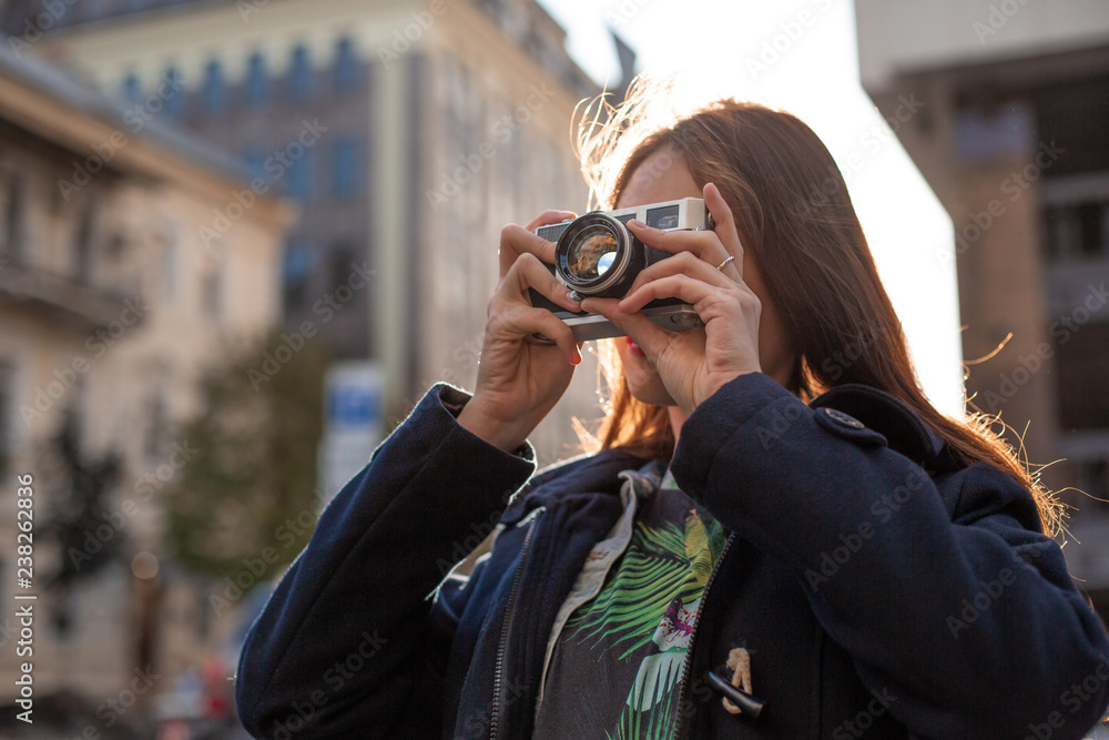Portrait of a pretty young tourist taking photographs with vintage retro camera Portrait of a pretty young tourist taking photographs with vintage retro camera