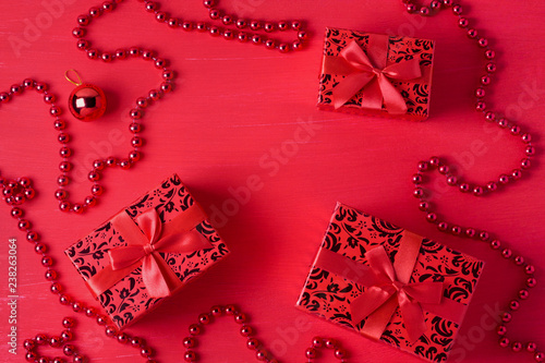 Christmas decor gift boxes bows beads red colors wooden background