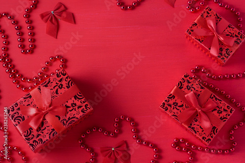 Fototapeta Naklejka Na Ścianę i Meble -  Christmas decor gift boxes bows beads red colors wooden background