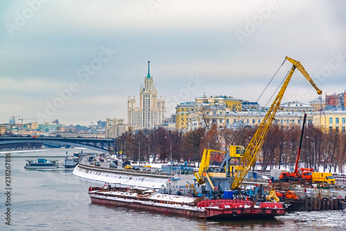 Heavy industrial crane based on floating pontoon. Construction of a new pier on the Moscow river.