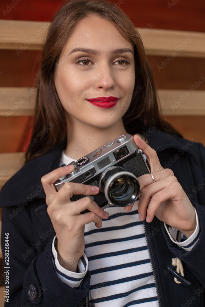 Happy young hipster woman holds retro photo camera Happy young hipster woman holds retro photo camera