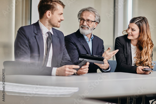 A couple of bussinessmen and bussines woman discussing an important topic