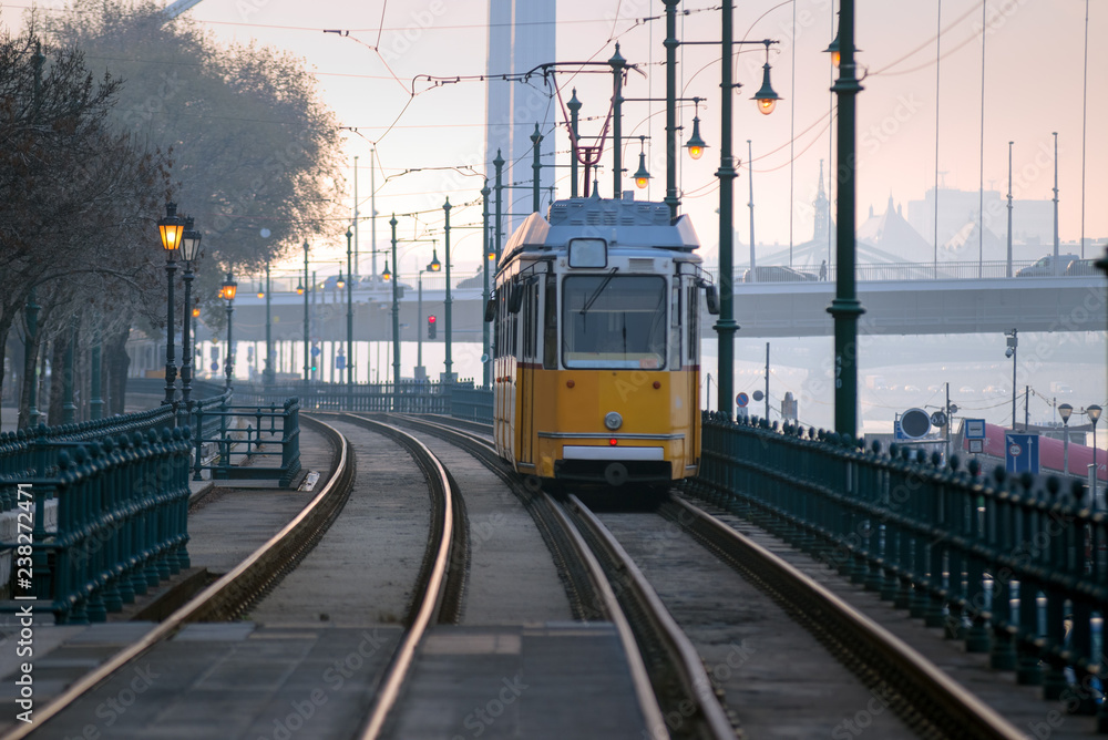 Old fashioned tram on a  riverfront tramway in Budapest city, early morning